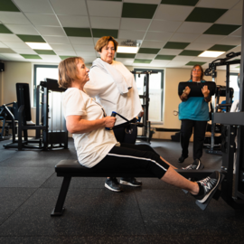 Vrouwen van middelbare leeftijd doen fitnessoefeningen in een sportschool.